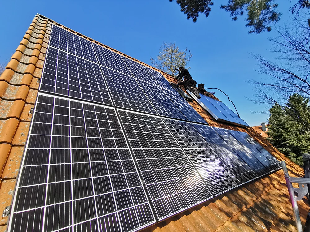 Mann installiert Photovoltaik auf einem Dach